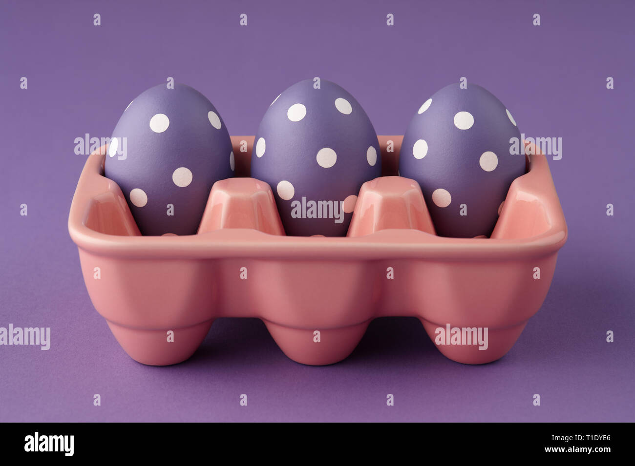 Pink ceramic egg tray with purple painted Easter eggs with dots on