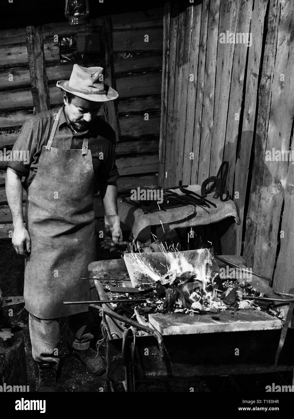Verona, Italy - December 26, 2018: Blacksmith heats the iron on the furnace fire. Stock Photo
