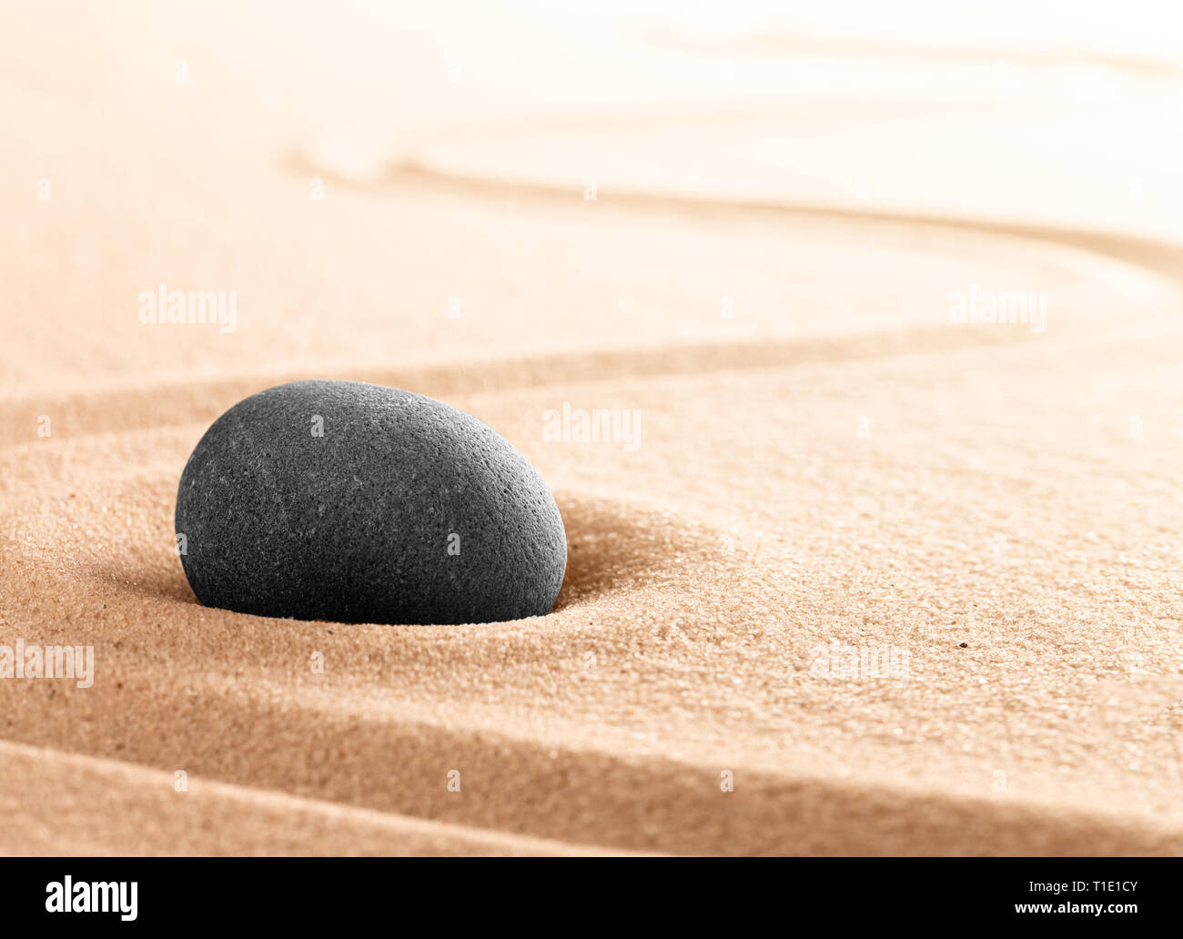Spa wellness or mindfulness stone and sand garden. Concentration or focus point for spiritual balance and purity of mind and soul. Sandy background wi Stock Photo