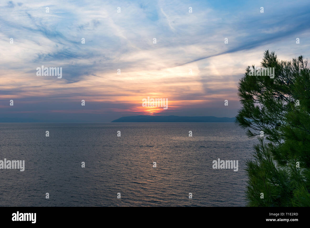 Sunset over the sea with mysterious sky with reflection in the water ...