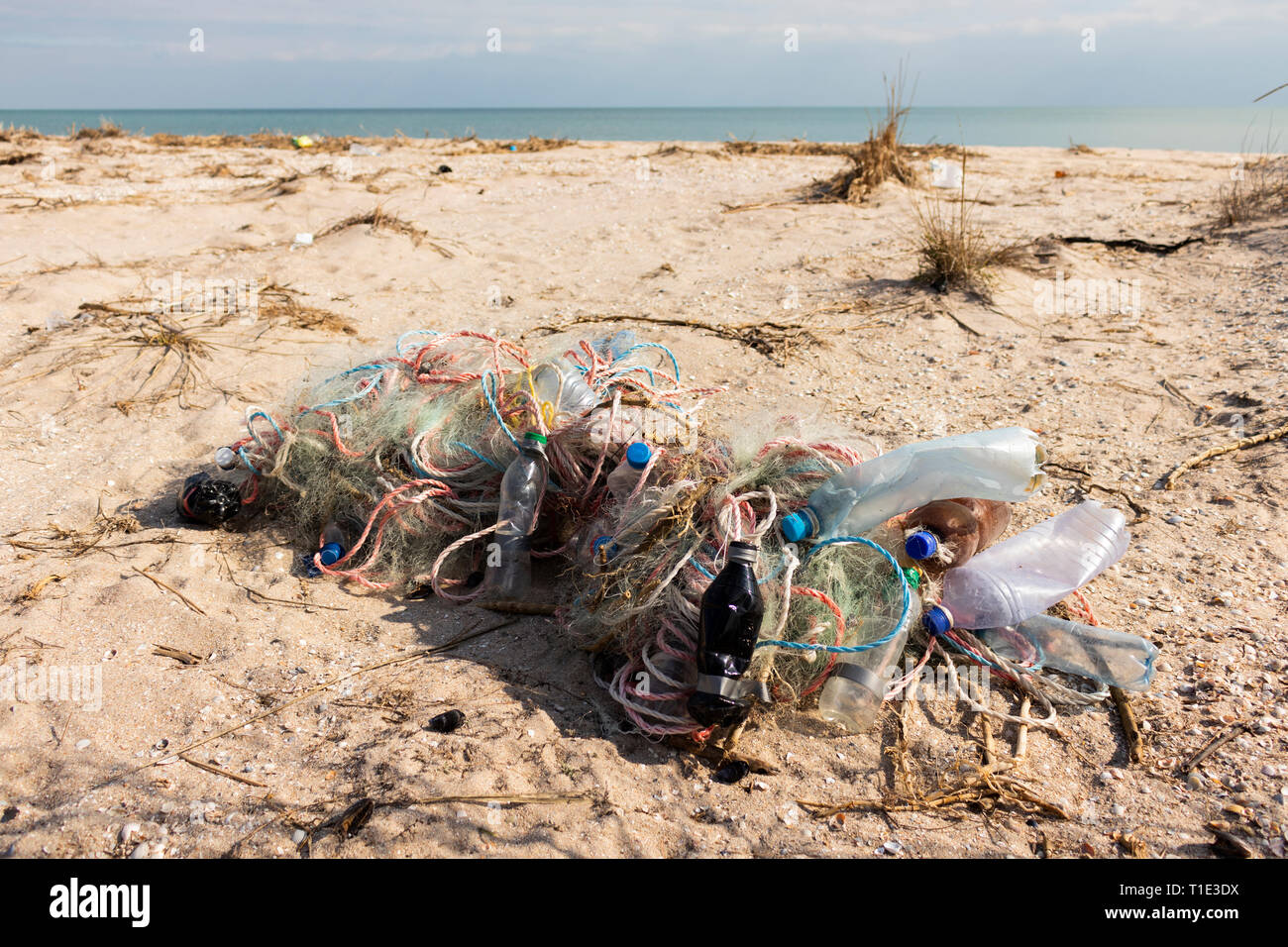 Empty plastic bottles and fishing nets on the sand. Garbage on beach