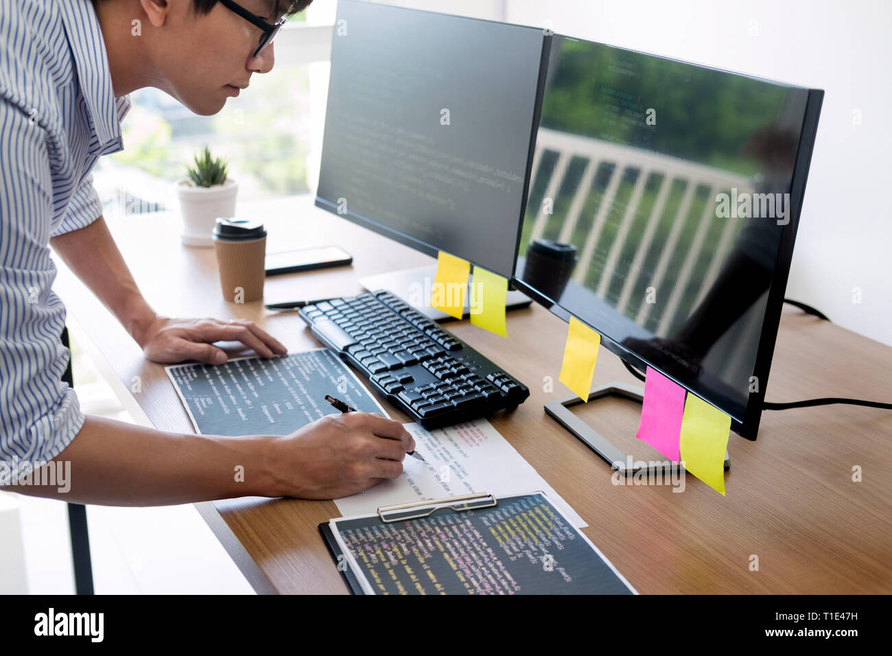 Serious busy hipster young web software developer programmer is coding or  programming on a desktop computer information in modern office technologies  Stock Photo - Alamy
