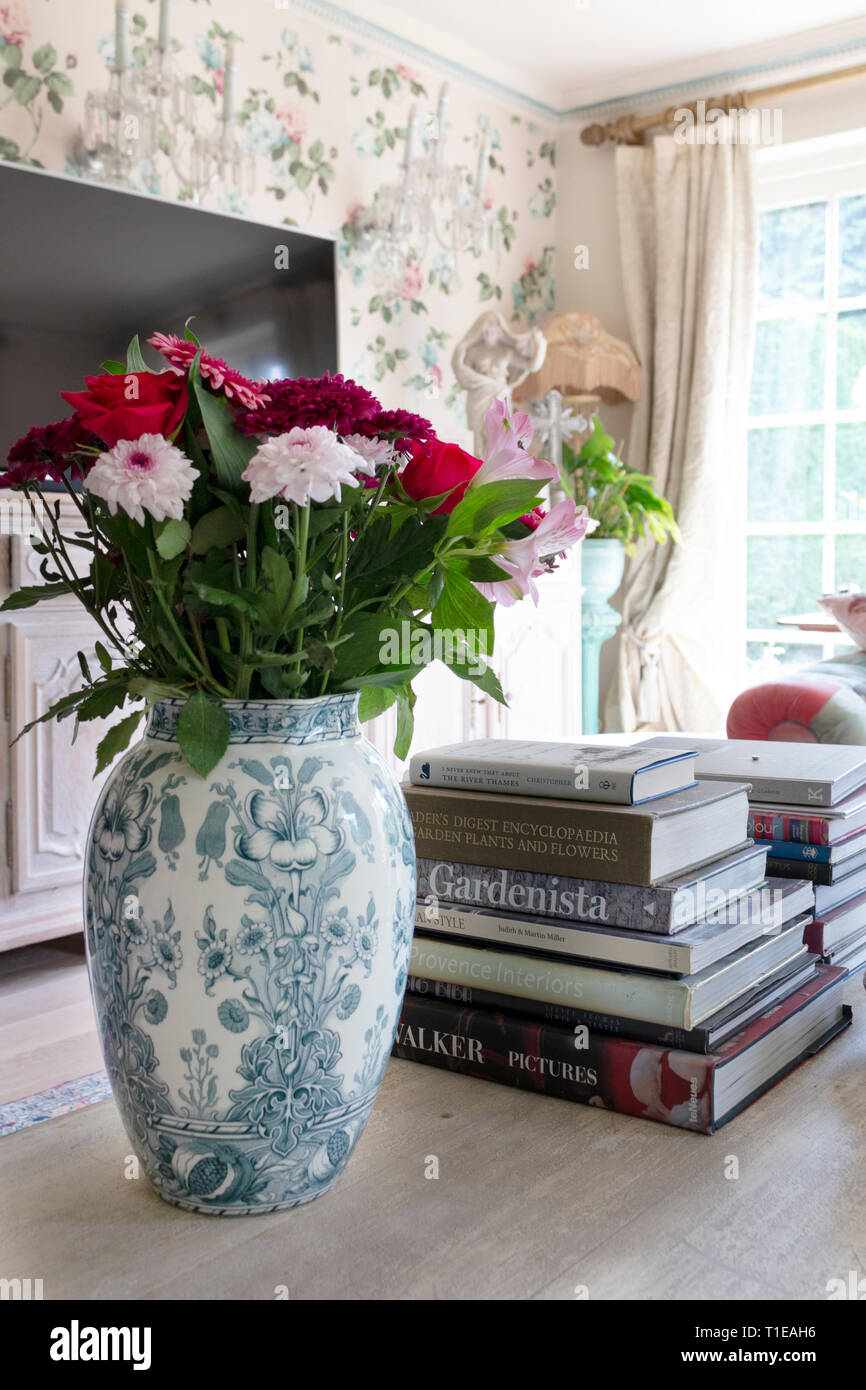 Tight crop of living room's coffee table featuring a vase of flowers