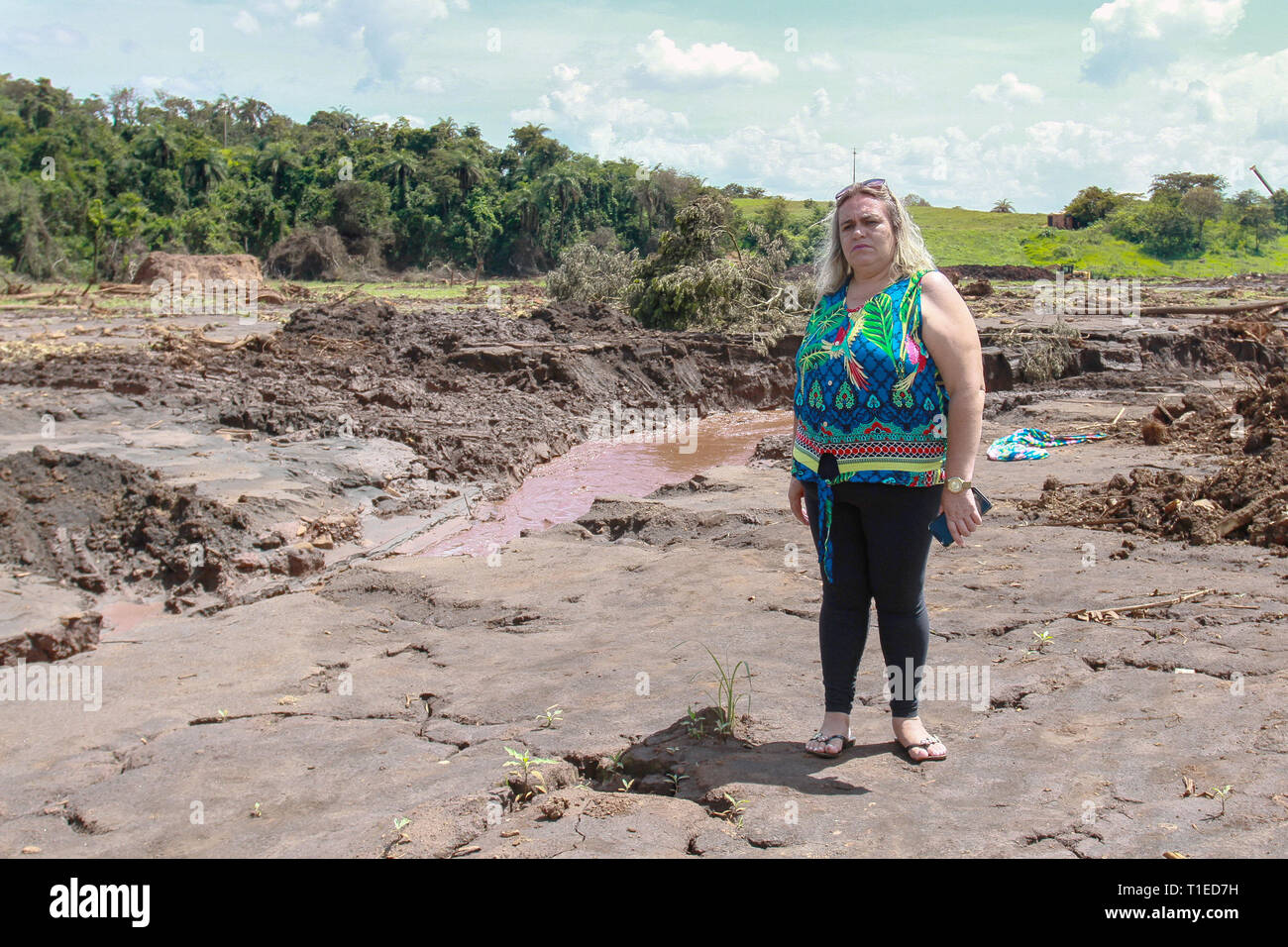 Brumadinho, Brazil. 18th Mar, 2019. Sueli de Oliveira Costa, sales manager, stands on the devastated earth. Her husband, Paulo Giovani dos Santos, died in the breach of the dam on 25.01.2019. The day changed the lives of thousands of people in the small Brazilian town of Brumadinho. Two months later, anger, grief and despair rule. (to dpa 'Everything is gone' - inhabitants of Brumadinho suffer from perineal tragedy') Credit: Rodney Costa/dpa/Alamy Live News Stock Photo