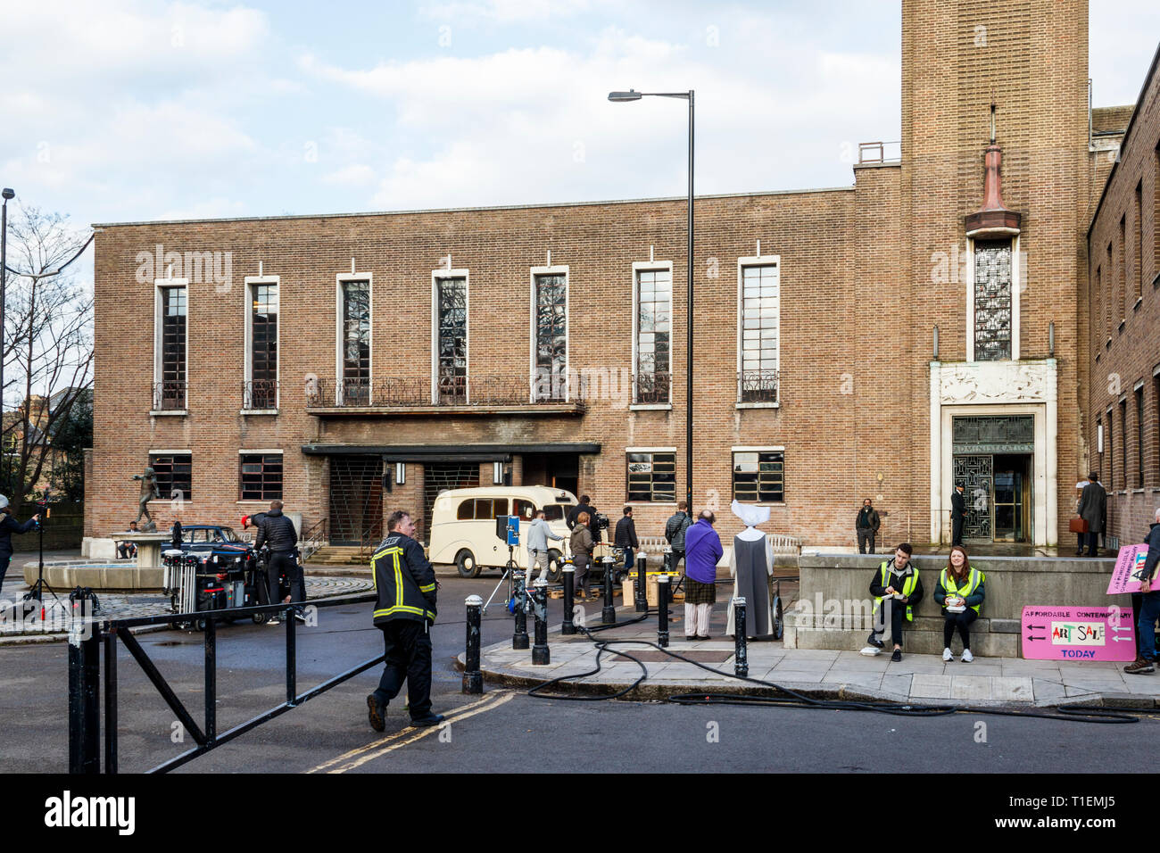 Crouch End, London, UK. 26th March 2019.  A production crew film a scene for 'Pennyworth', an upcoming American drama TV series featuring the early life of Batman's faithful butler Alfred. The art deco town hall is a popular location for film and TV productions. Credit: Michael Heath/Alamy Live News Stock Photo