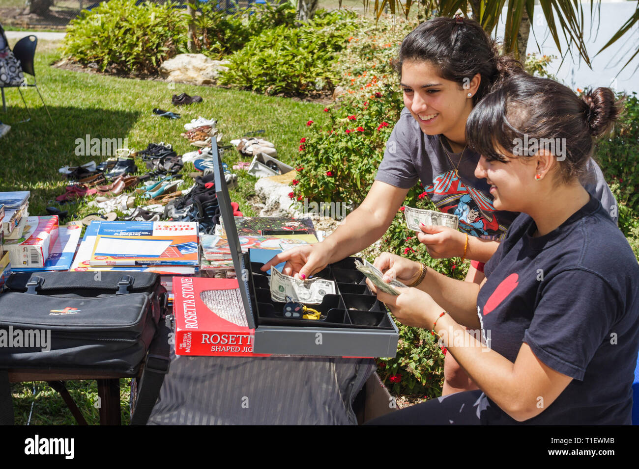 Miami Beach Florida,Parks & Recreation,Cheerleader Yard Sale raise fundraiser cash box counting money,Hispanic teens teenagers teenage girls Stock Photo