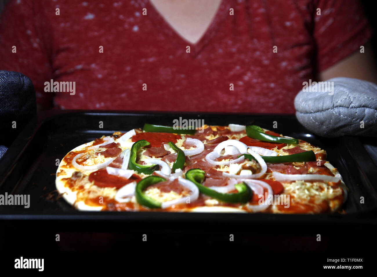 Photo Of A Ham Pepperoni Cheese With Green Bell Pepper Pizza Held By A Person With Oven Mitten Stock Photo Alamy
