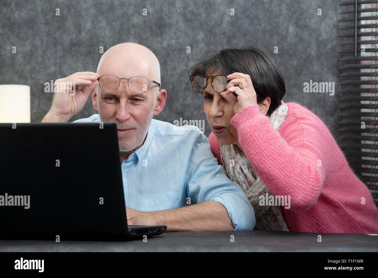 a senior couple using laptop, they having difficulties and vision problems Stock Photo
