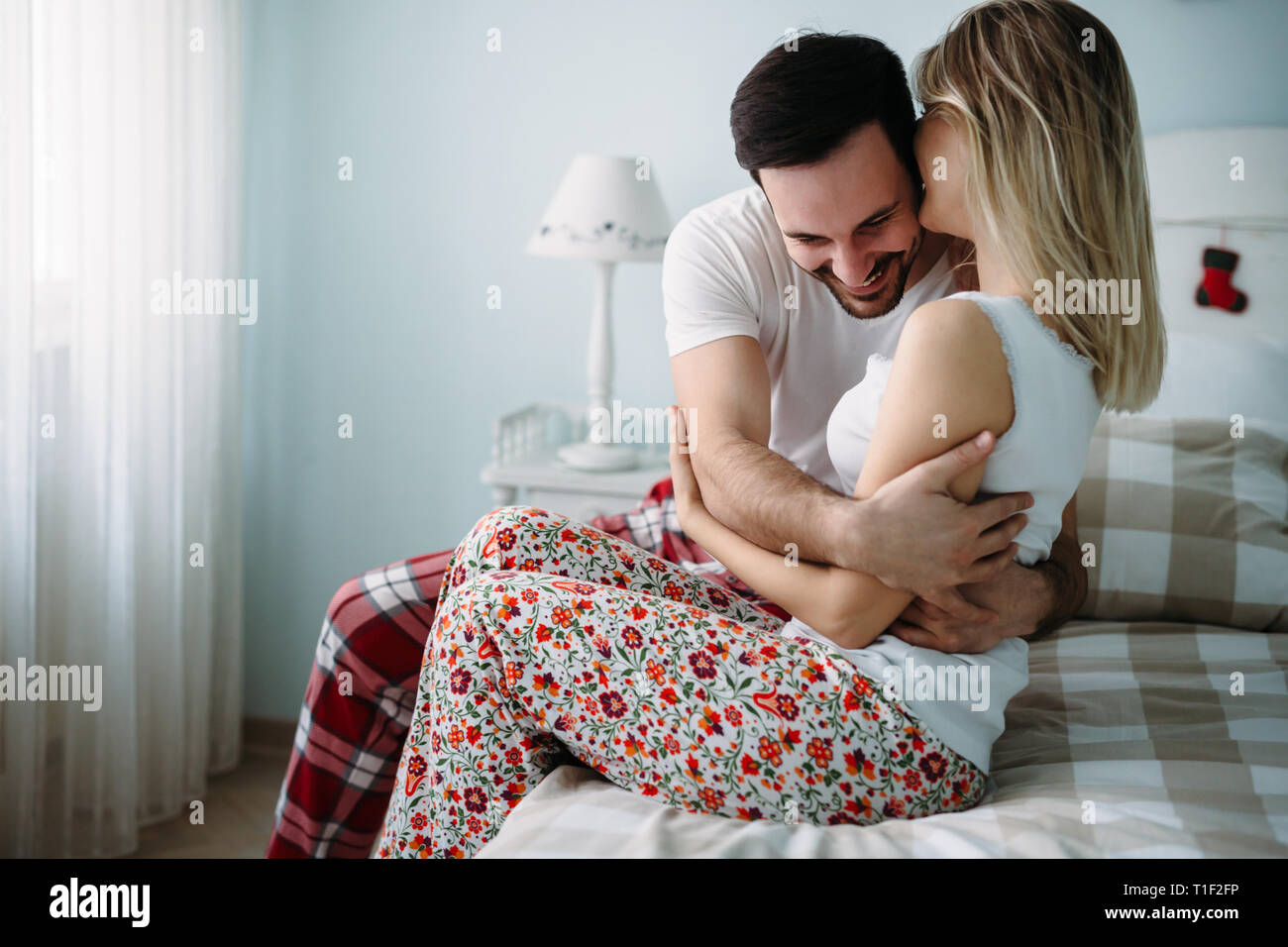 Portrait of young loving couple in bedroom Stock Photo