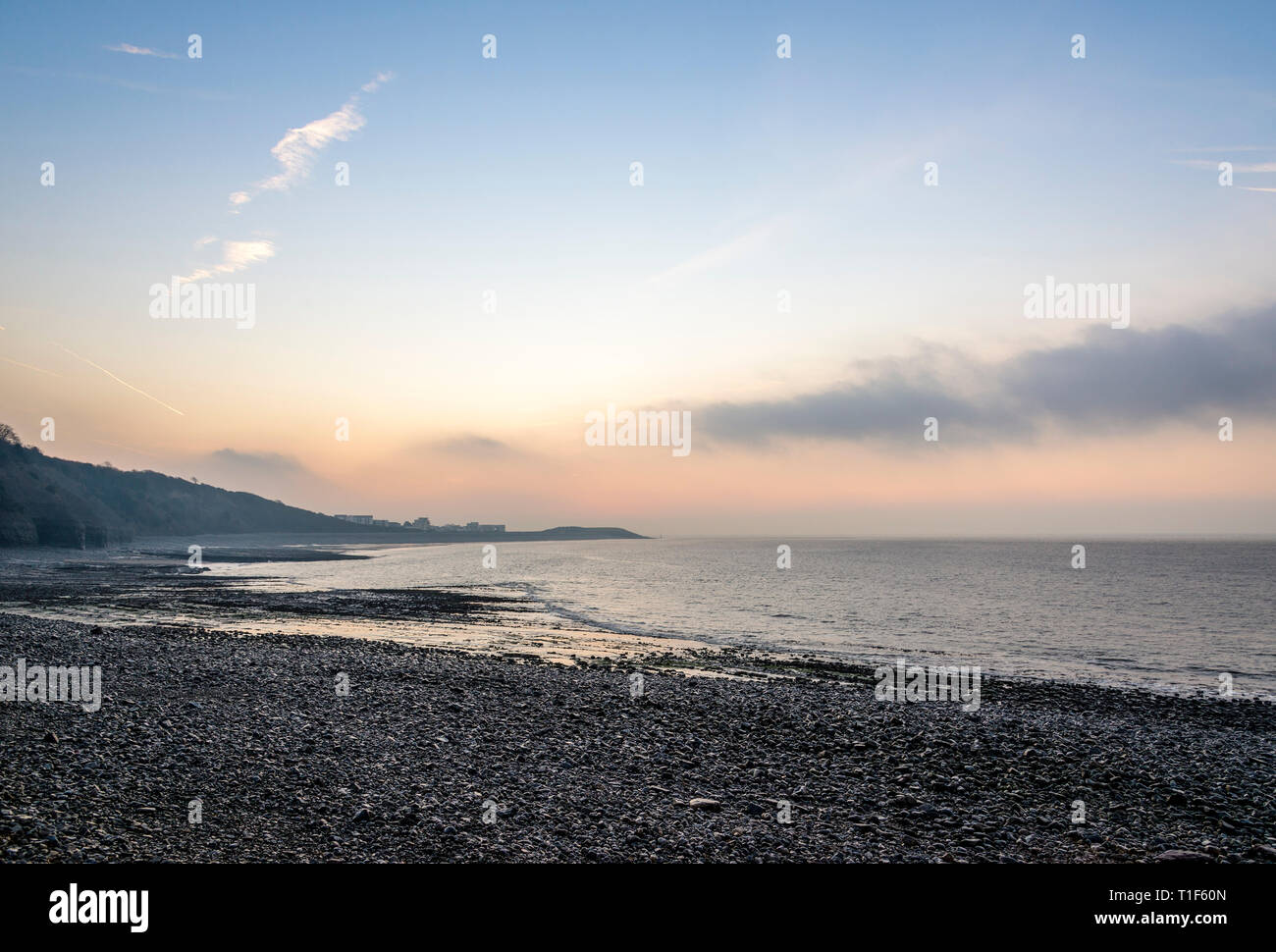 A tranquil scenic view, just before sunrise, of the long pebble beach at the Knap, Barry, South Wales Stock Photo