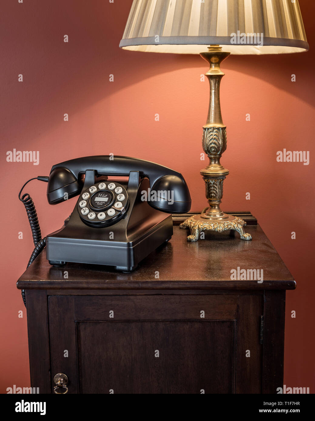 'Old telephone and lamp on bedside table in The Zetter Townhouse in London, England' Stock Photo