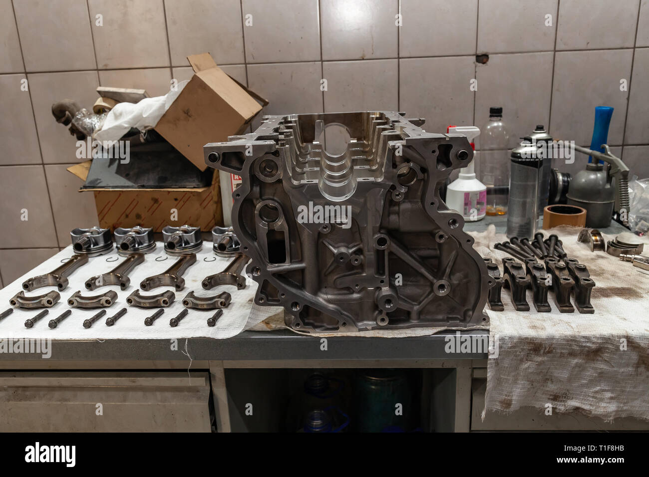 Engine connecting rods and pistons used and removed from a four-cylinder engine on a white soft cloth in a vehicle repair workshop. Auto service indus Stock Photo