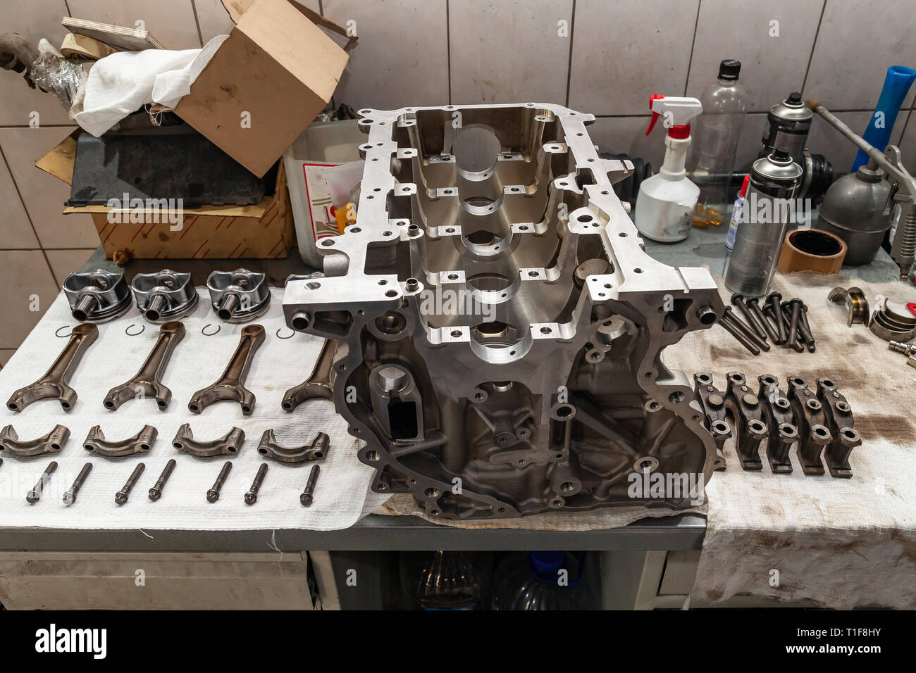 Engine connecting rods and pistons used and removed from a four-cylinder engine on a white soft cloth in a vehicle repair workshop. Auto service indus Stock Photo