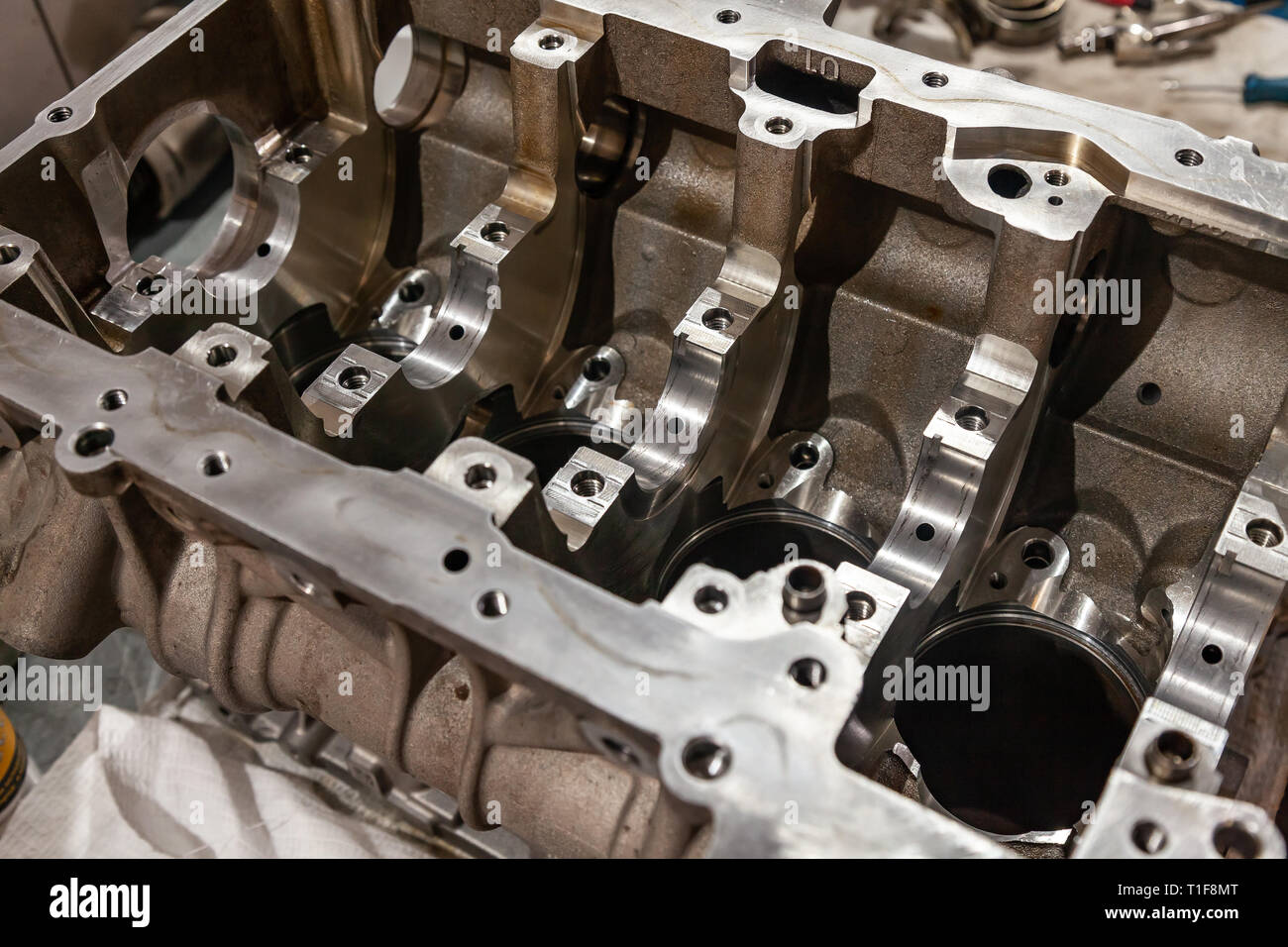 A four-cylinder engine dissembled and removed from car on a workbench in a vehicle repair workshop. Auto service industry. Stock Photo