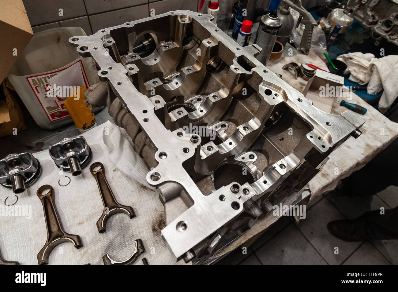 A four-cylinder engine dissembled and removed from car on a workbench in a vehicle repair workshop. Auto service industry. Stock Photo