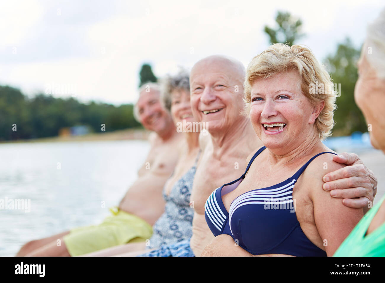 Active seniors go on holiday together at the lake in summer Stock Photo