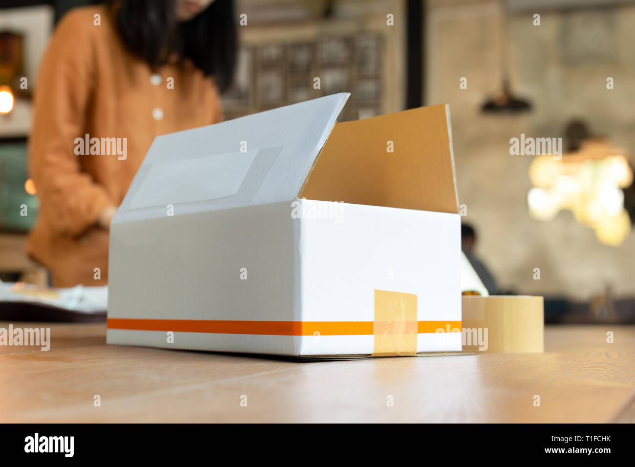 Startup small business woman owner packing cardboard box at workplace ...