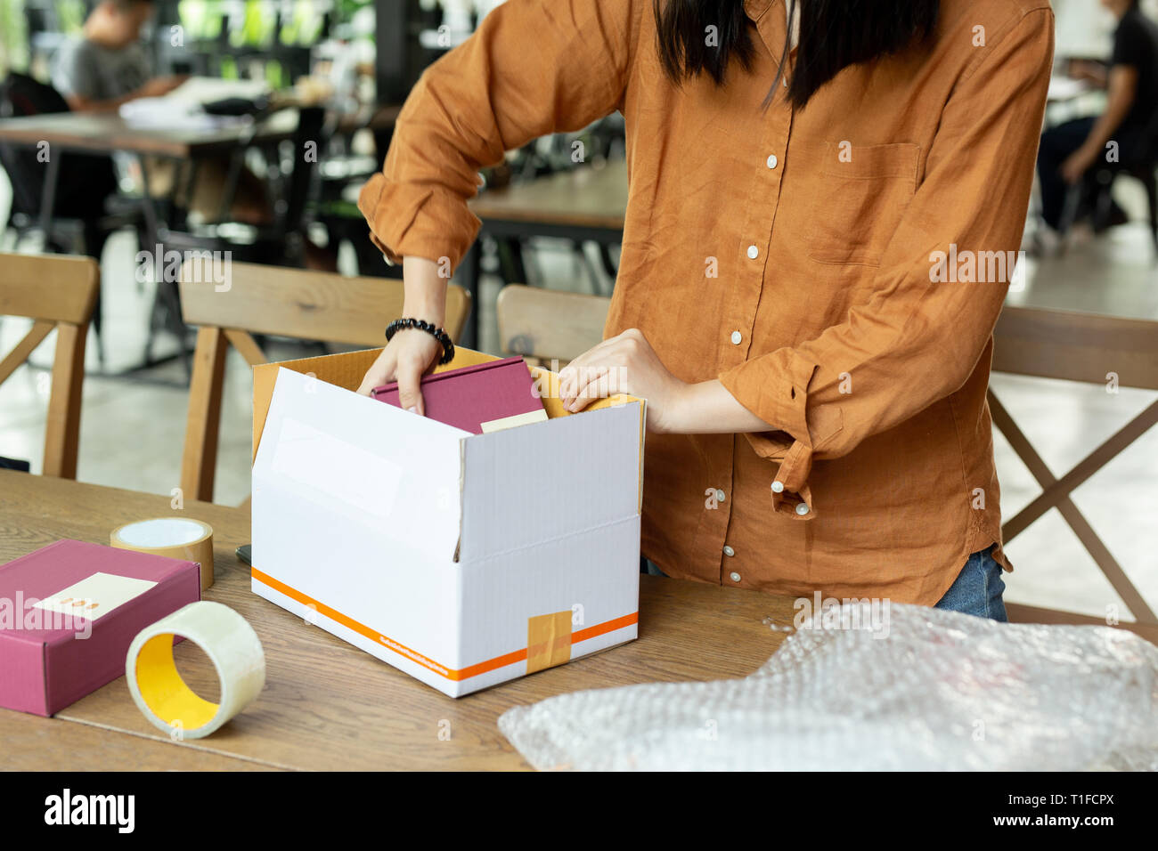 Startup small business woman owner packing cardboard box at workplace ...