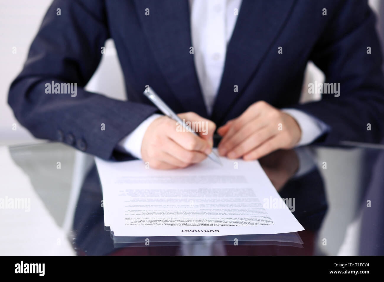 Unknown female hands with pen over document of contract. Agreement ...