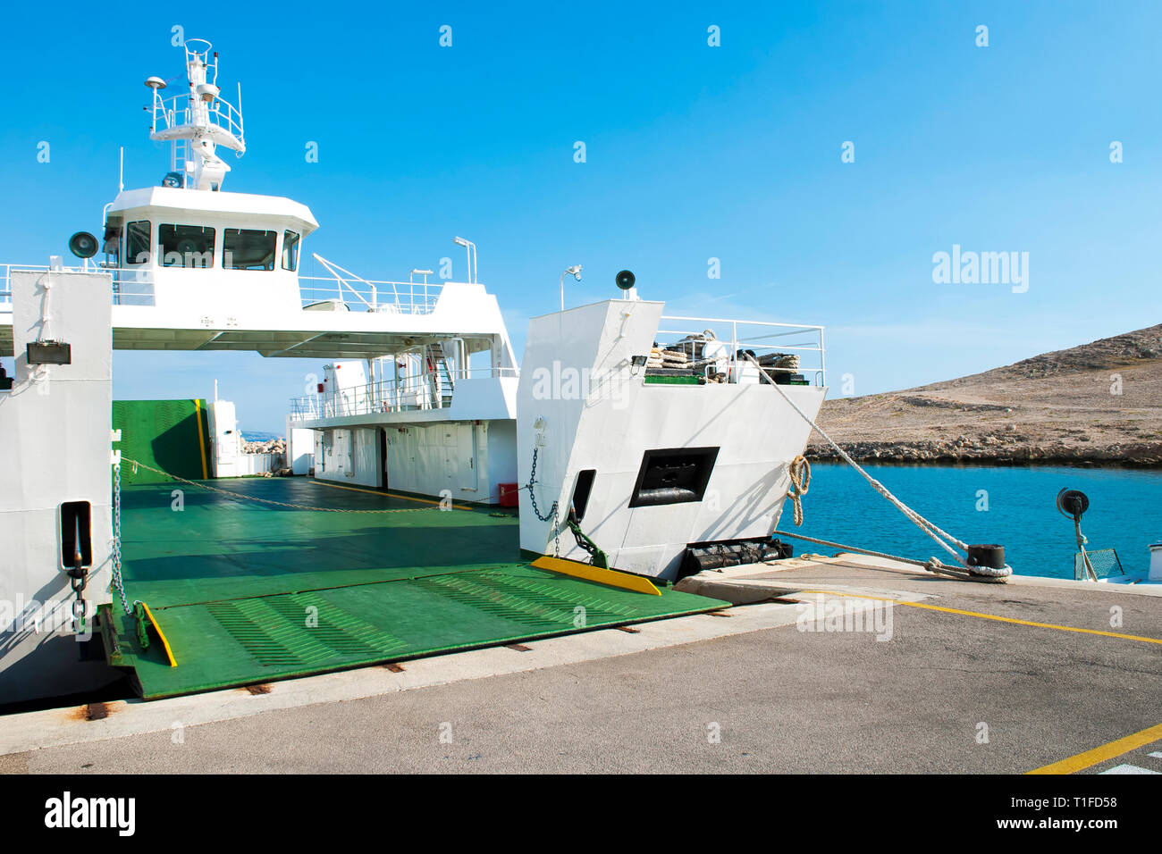 Car ferry boat in Croatia linking the island Rab to mainland with open ramp, waiting for boarding. Stock Photo