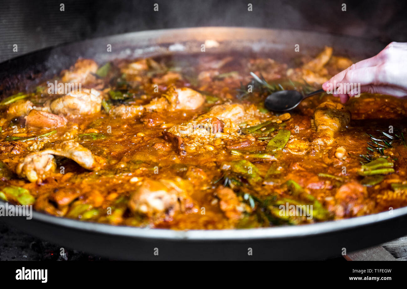 Cooking and making a traditional Spanish Paella over open fire