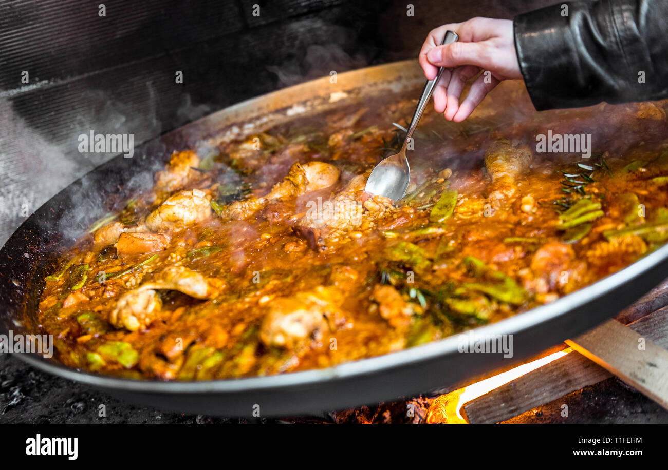 Cooking and making a traditional Spanish Paella over open fire