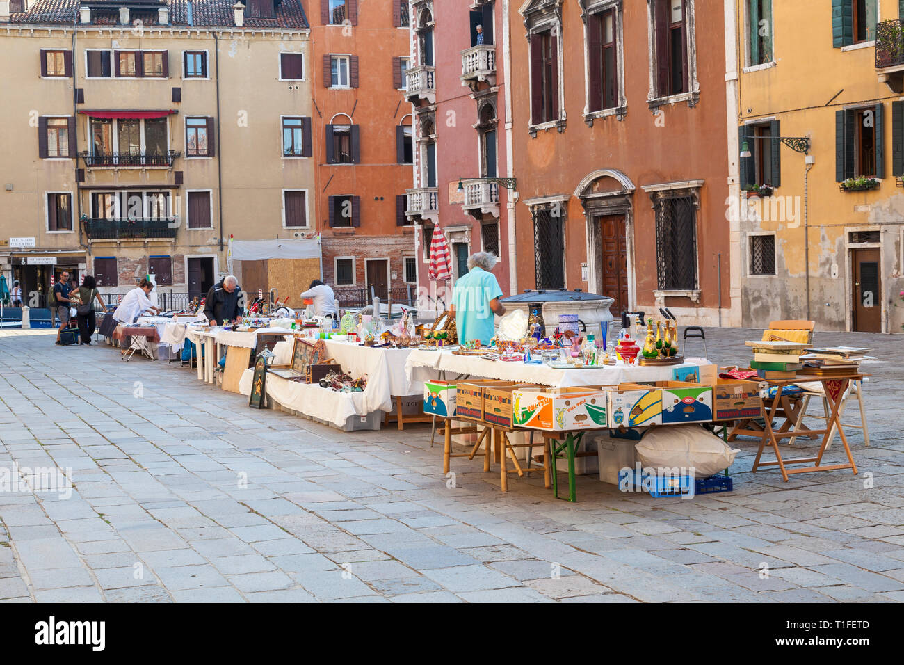 Antiques market or Bric-a-Brac sale in campo dei Frari, San Polo, Venice, Veneto, Italy with open air tables early morning. Dealers setting up shop fo Stock Photo