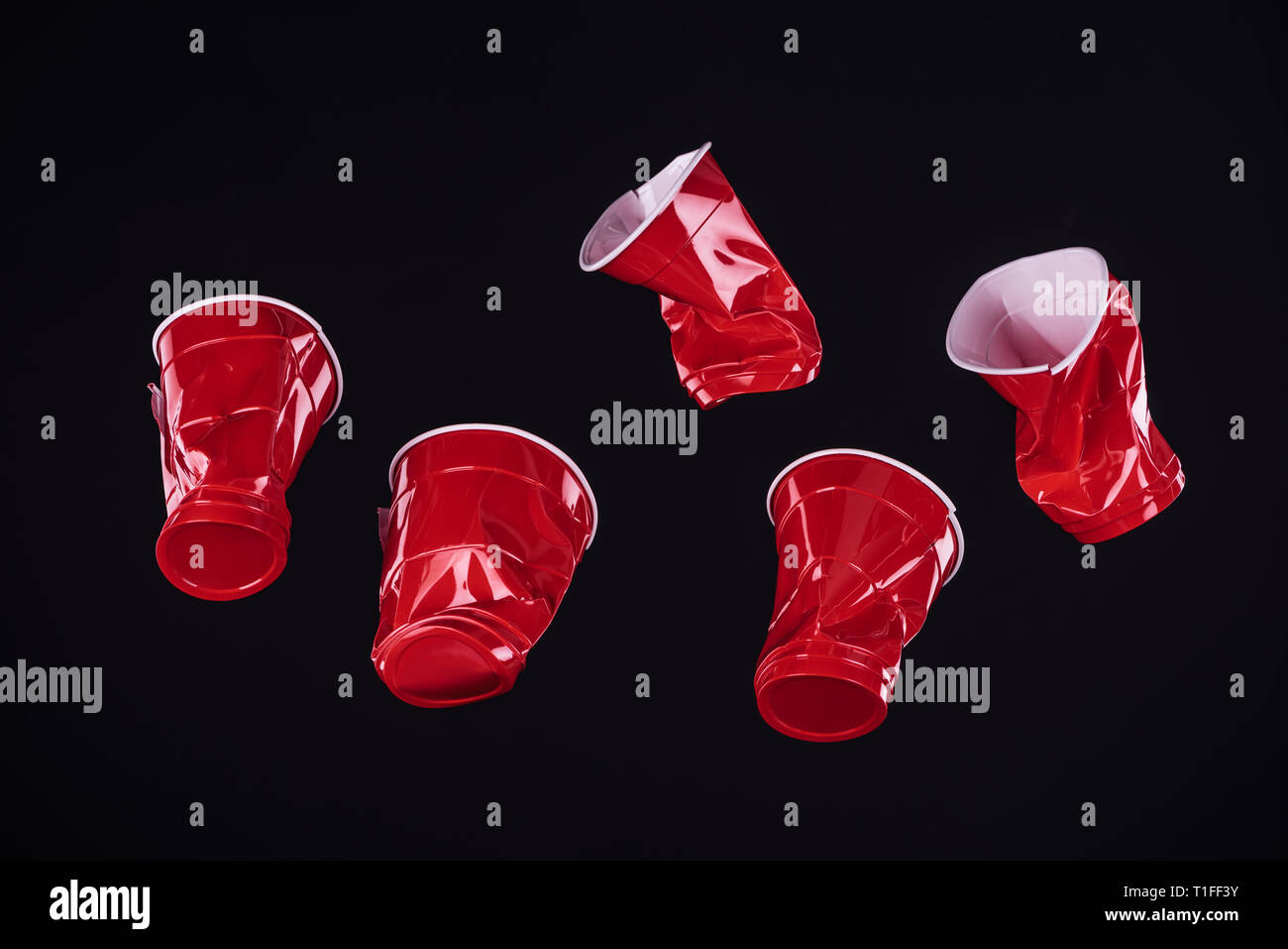 top view of bright and colorful, red plastic cups isolated on black with copy space Stock Photo