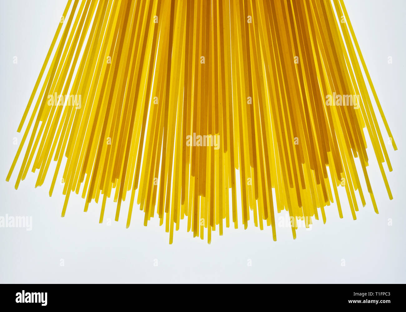 Dried pasta spaghetti on a white background, long and thin solid