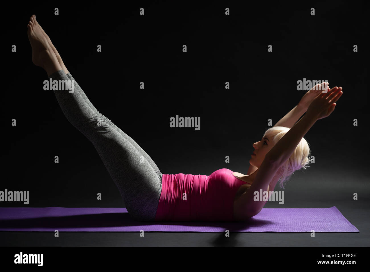 Woman exercising pilates. Double leg stretch exercise Stock Photo