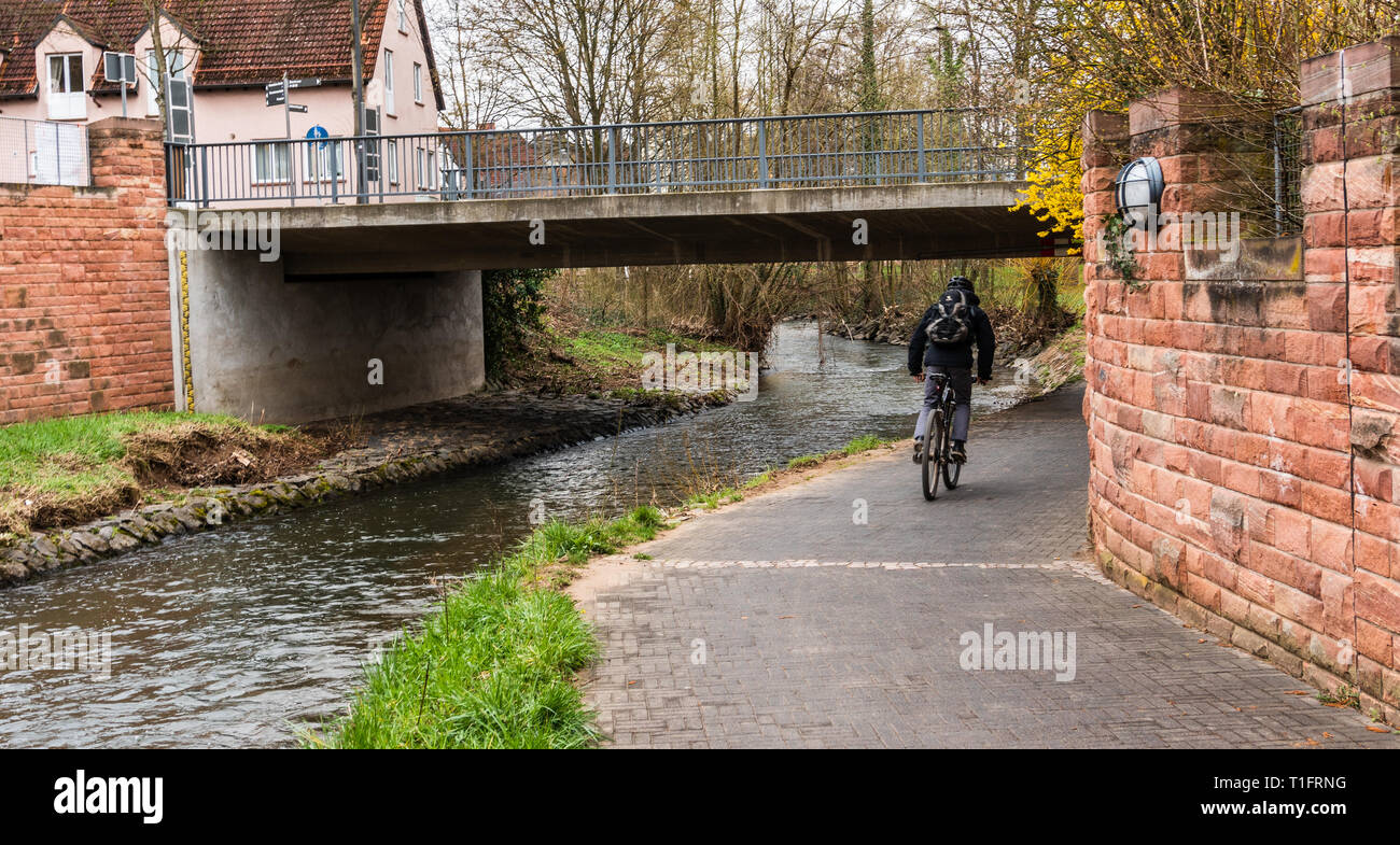 Cyclist with a backpack on the bicycle path to the river. Stock Photo
