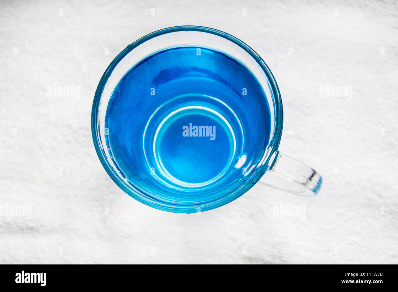 Clean drinking water with bubbles in a clear blue glass. Quench your