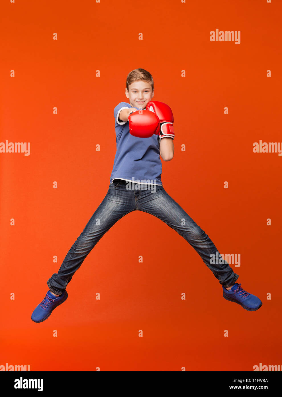 Little kid gesturing with boxing gloves on orange Stock Photo Alamy
