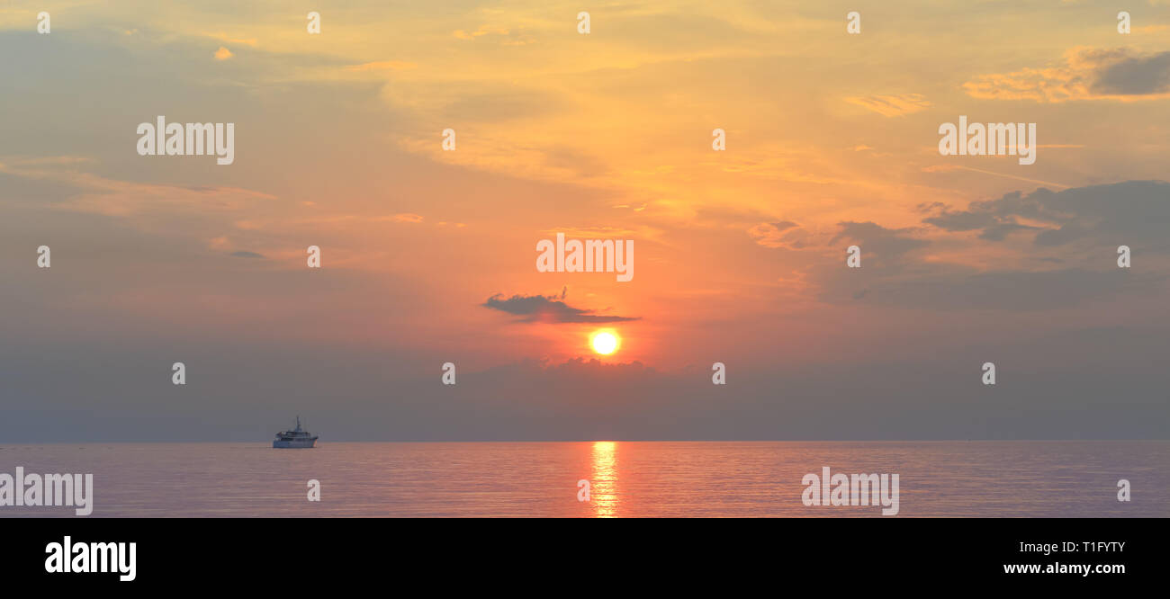 Sunset above the Adriatic sea in summer.Seascape with beautiful view of shimmering calm sea in the evening. Stock Photo