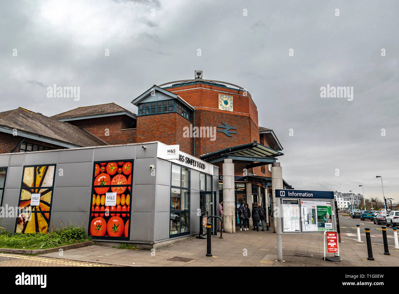 Guildford, United Kingdom - March 23, 2019: Street view of the entrance of the railway train station with Marks And Spencer shop in the medieval city  Stock Photo