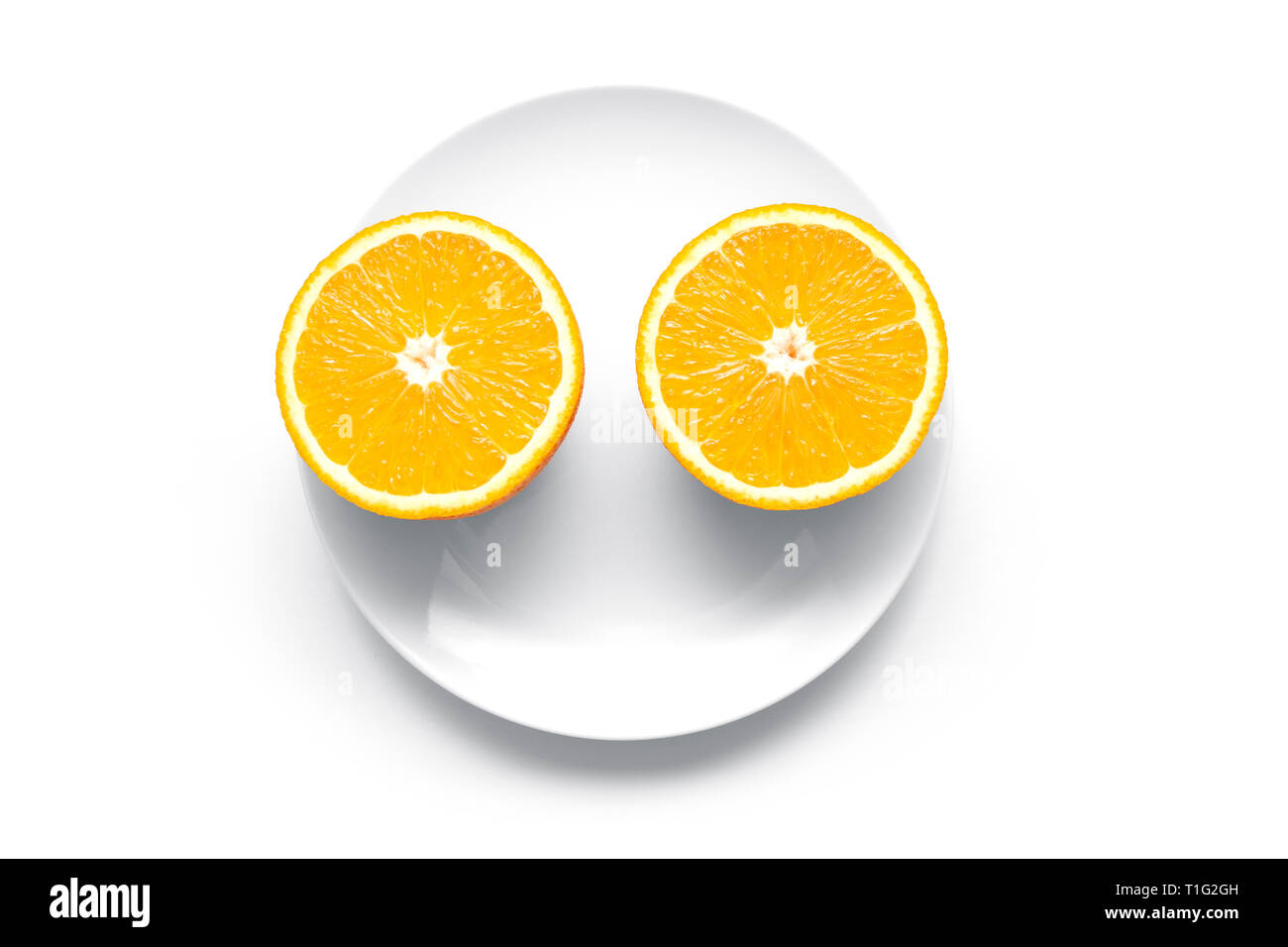 Two ripe orange parts on a round plate Stock Photo