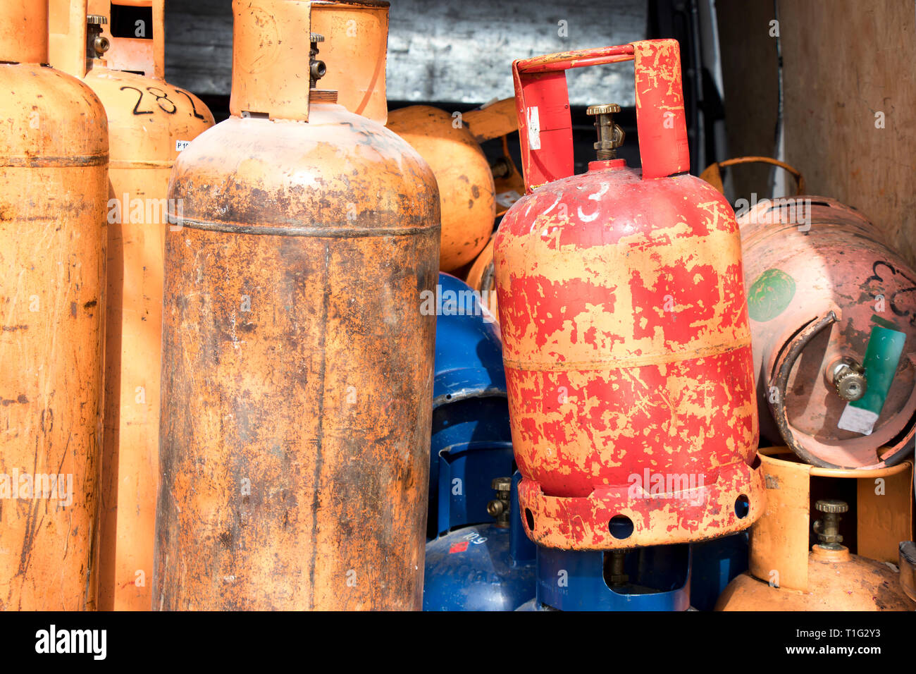 Different color and size cylinder gas bottles stored for refill and supply Stock Photo