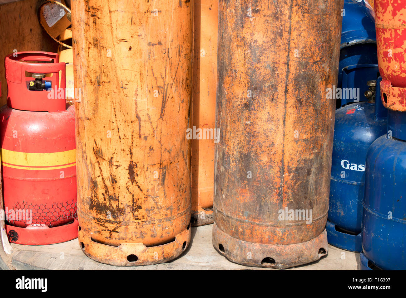 Different color and size cylinder gas bottles stored for refill and supply Stock Photo