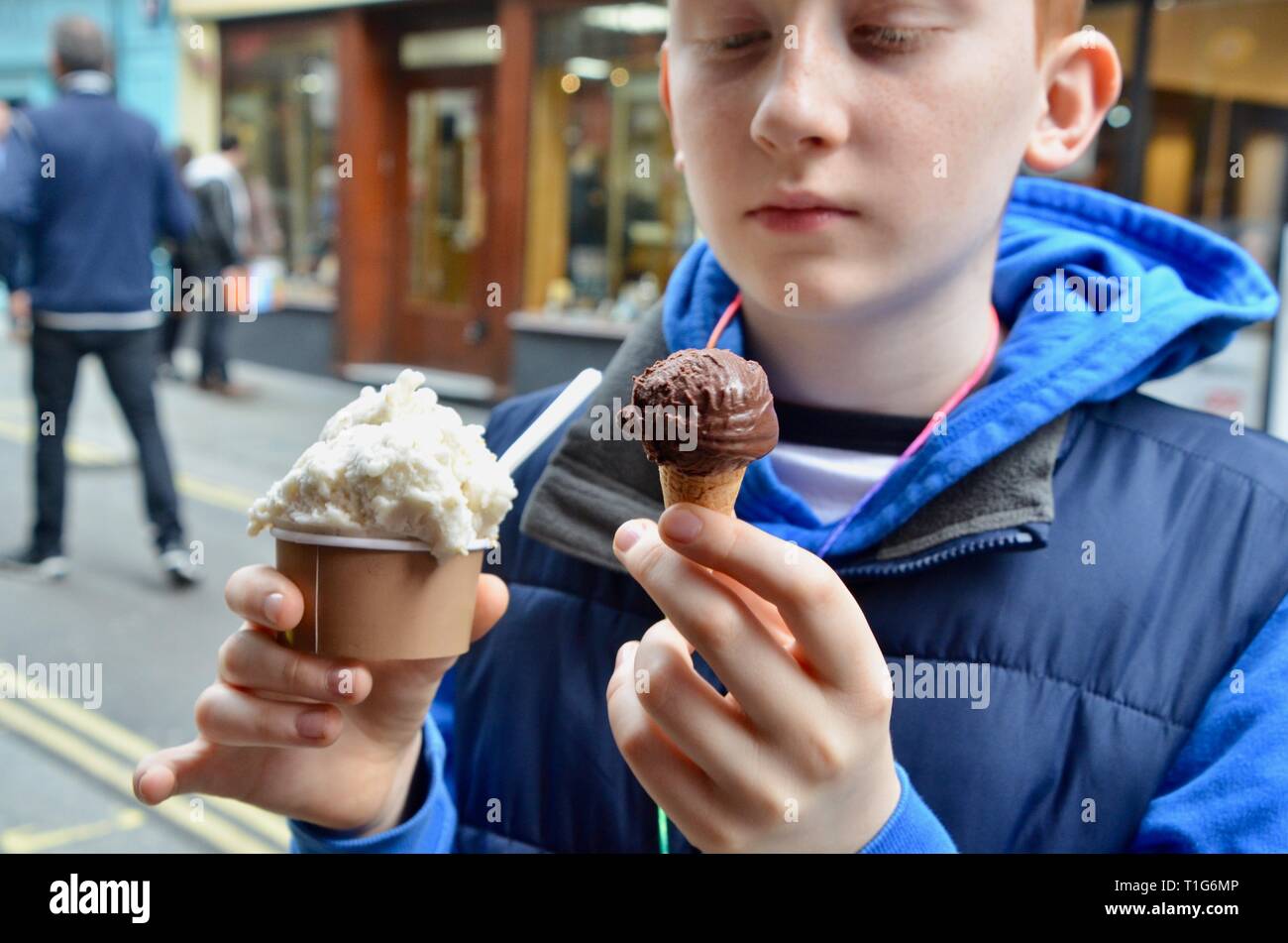 boy in blue hoodie holding La Gelatiera ice creams Stock Photo