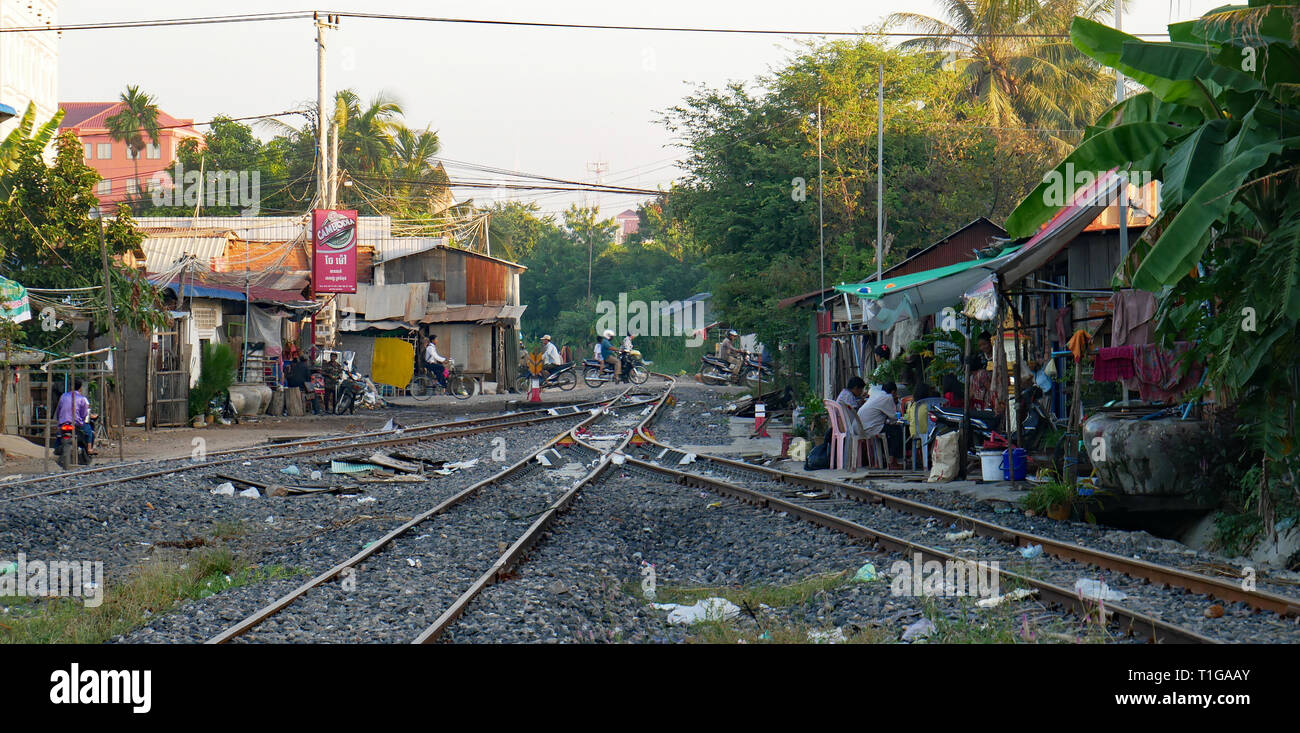 People living beside a railway line. Family life goes on beside a litter strewn railroad track near Battambang, Cambodia, train station. Dec 2018 Stock Photo