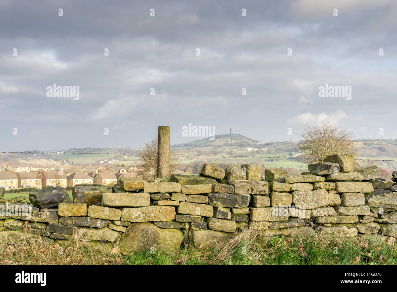 Dry stone wall in the foreground with castle hill and the Jubilee Tower in the Background, Huddersfield, West Yorkshire, England, UK. Stock Photo