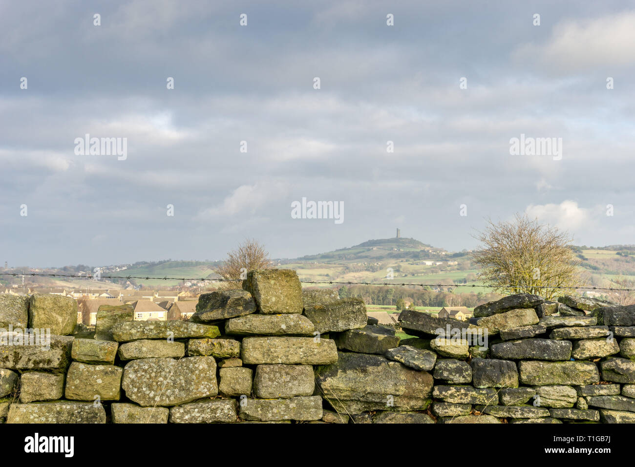 Dry stone wall in the foreground with castle hill and the Jubilee Tower in the Background, Huddersfield, West Yorkshire, England, UK. Stock Photo