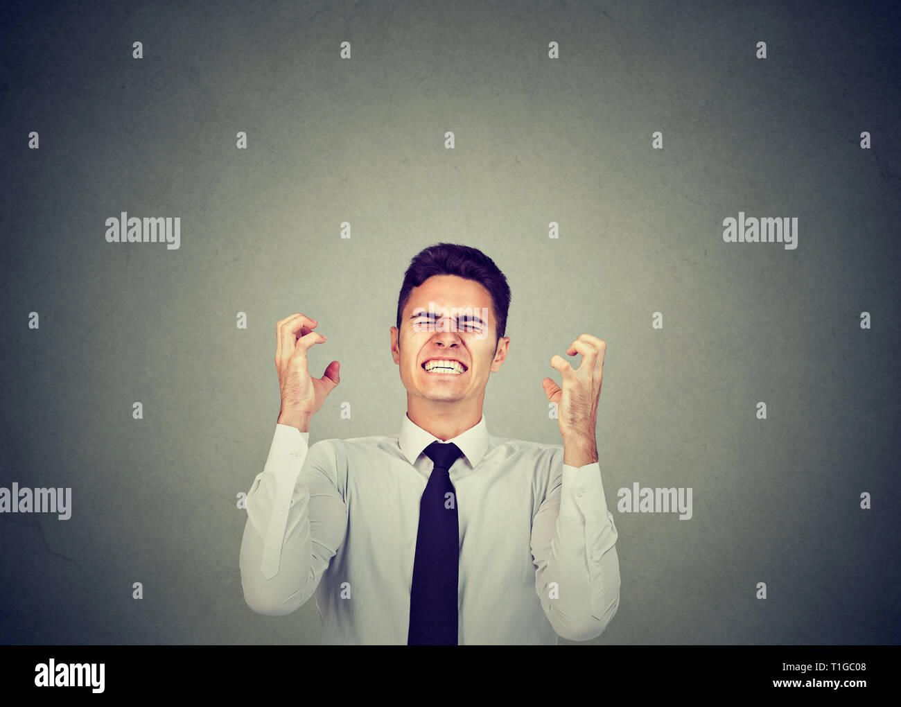 Angry business man shouting in frustration and gesturing with hands Stock Photo