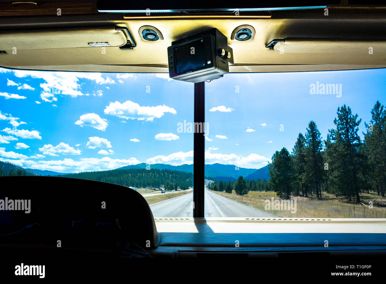 View from the inside of an RV looking out the front windshield to an endless road stretching out in western Montana on I-90 interstate highway, USA Stock Photo