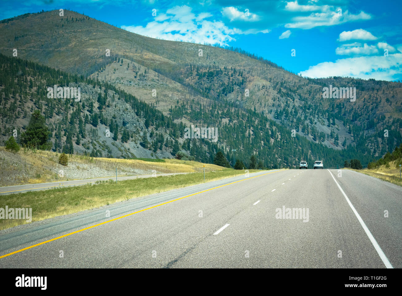 A big sky country view of interstate I-90 traveling in Southwest Montana surrounded by mountains 