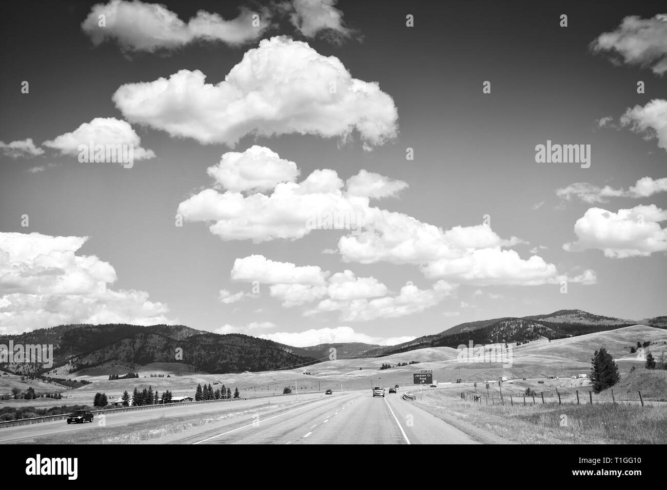 A sweeping view of big sky country near Bozeman, Montana on Interstate I-90 freeway with rolling foothills for an American Road trip Stock Photo