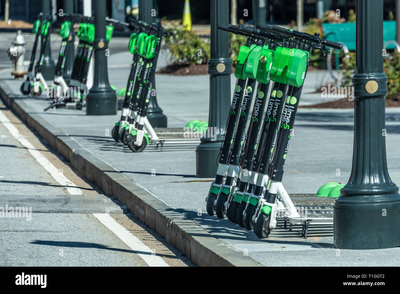 Lime-S rental scooters line the street along Centennial Olympic Park in downtown Atlanta, Georgia, USA. Stock Photo