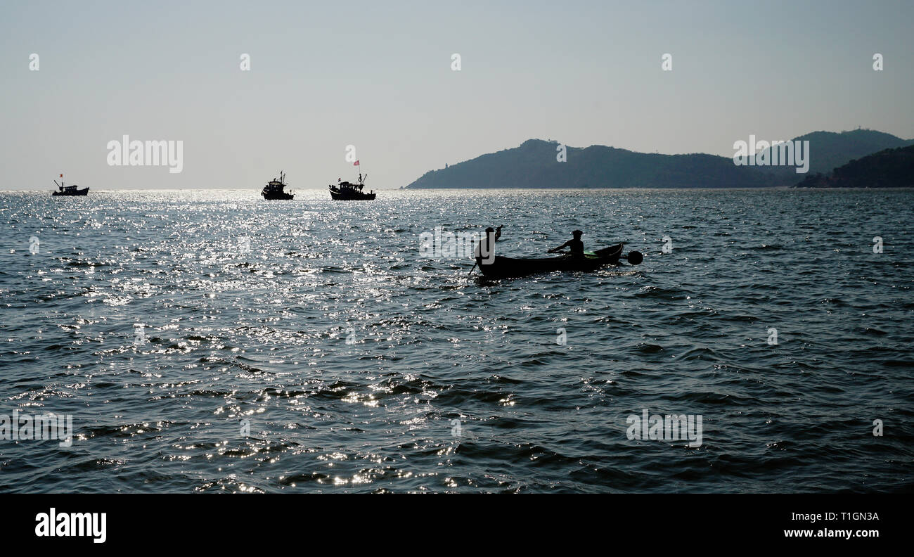 fishing boat  with  people and  ships. Wonderful   and  hard life. Backlight.  South India. Stock Photo