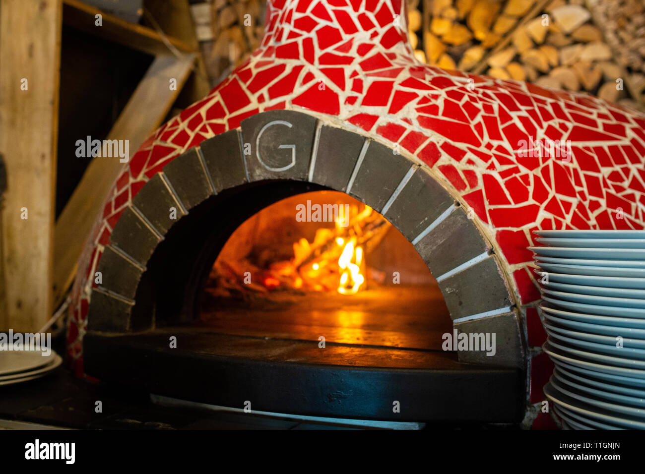 Verbeteren Buitenlander Duplicaat a traditional italian wood fired pizza oven with red mosaic in a  pizzeria/trattoria/restaurant Stock Photo - Alamy