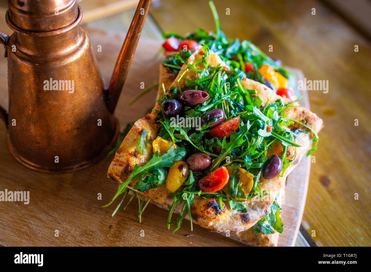 Authentic Italian Roman style vegan pizza slices on a wooden board in a pizzeria Trattoria style restaurant. Italian street food Stock Photo